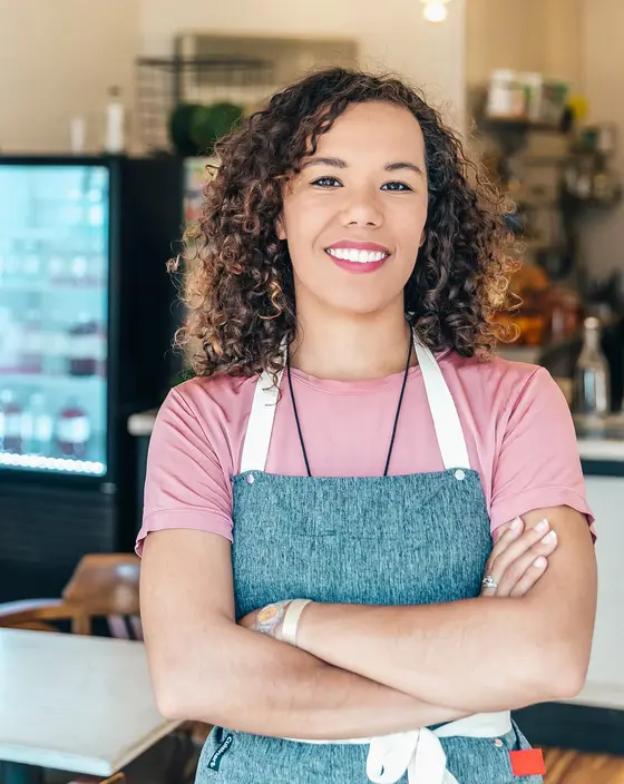 Café owner standing proudly behind her counter