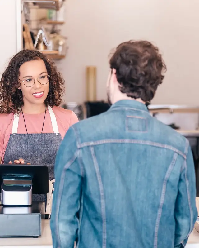 Café owner serving a customer at the till