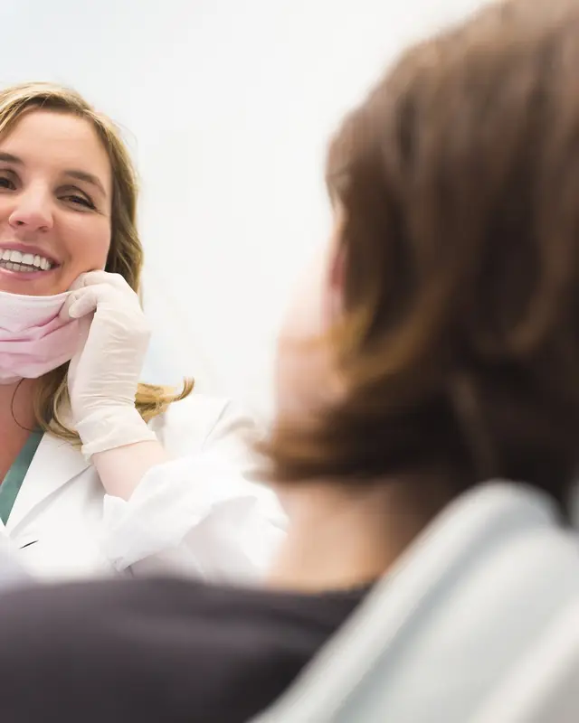 Dentist smiling at a patient in the chair