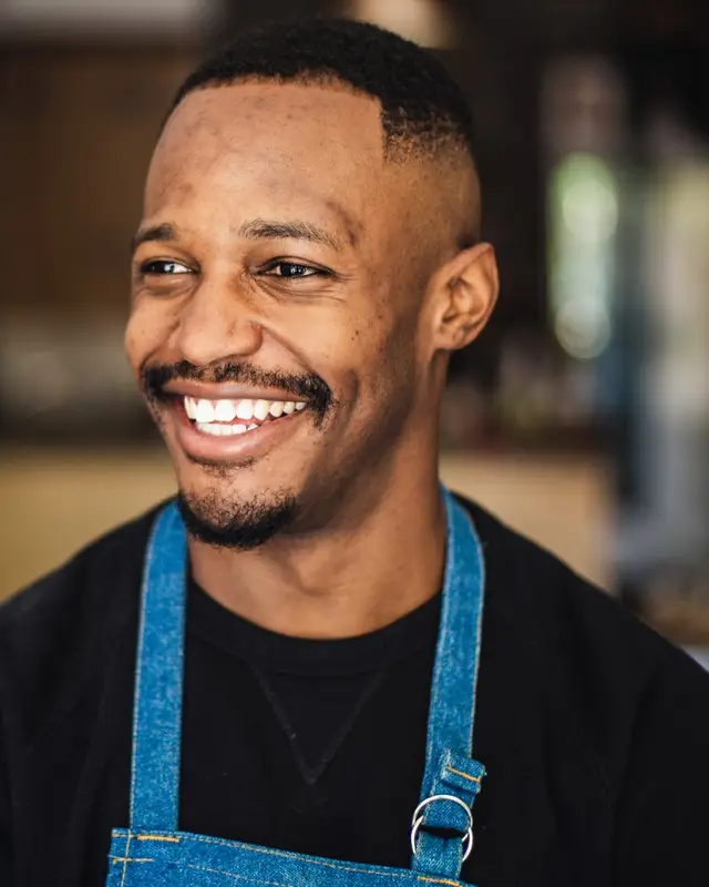 Shop owner smiling in his clothing store